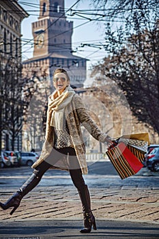 Smiling elegant woman in fur coat in Milan, Italy walking