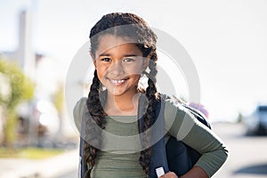 Smiling elementary school girl with bagpack