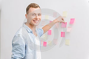 Smiling employee is busy with post-it notes