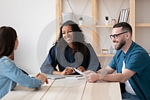 Smiling employers interview female job candidate at meeting