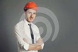 Smiling engineer folds his arms