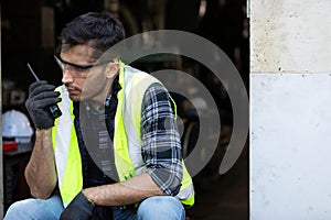 Smiling engineer man or factory worker using walkie-talkie and feeling happy