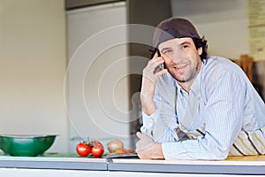 Smiling entrepeneur making a phone call in his takeaway food sta photo