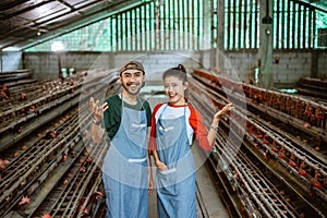 smiling entrepreneur couple with hand gesture offering something at farm