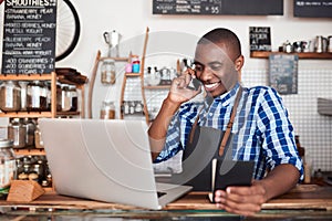 Smiling entrepreneur hard at work on his cafe business