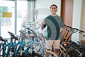 smiling entrepreneurial man with thumbs holding a digital tablet