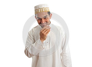 Smiling ethnic man in traditional robe and topi