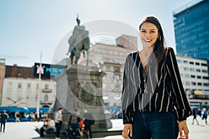 Smiling excited female tourist visiting Zagreb, Croatia. Walking tour sightseeing in the city centre. Croatian capital tourism.