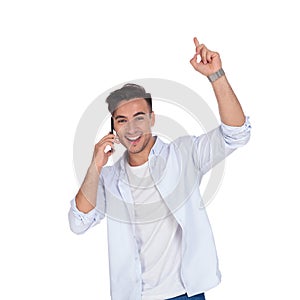 Smiling excited man talking on the phone and points up
