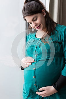 Smiling Expectant Mom Holding Her Budding Baby Bump