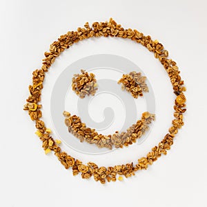 Smiling face of cereal flakes on white background
