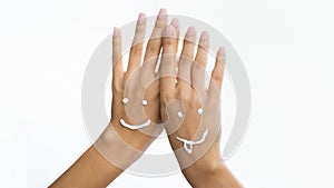 Smiling faces. Woman applying moisturising cream on hands