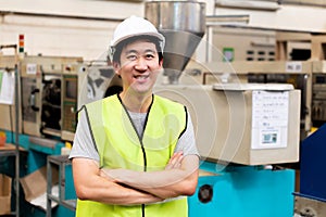 Smiling factory worker with safety hard in industrial facilities