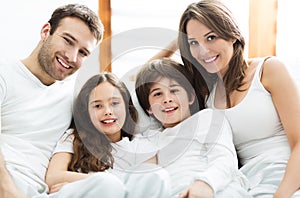 Smiling family in bed