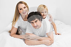 Smiling family in bed