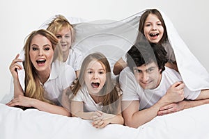 Smiling family in bed