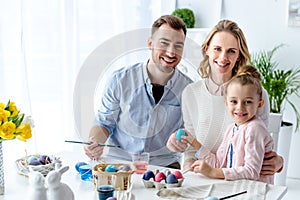 Smiling family with daughter coloring