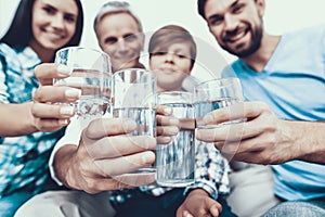 Smiling Family Drinking Water in Glasses at Home.