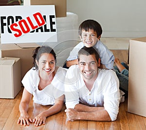 Smiling family on the floor after buying house