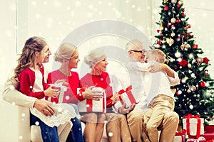 Smiling family with gifts hugging at home