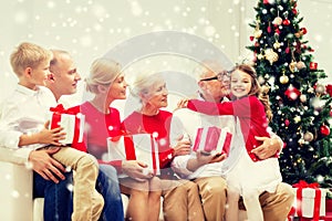 Smiling family with gifts hugging at home