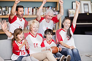 Smiling family with grandparents watching American football match