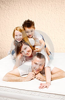 Smiling family having fun lying on the bed