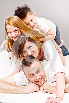 Smiling family having fun lying on the bed