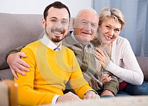 Smiling family hugging sitting on sofa