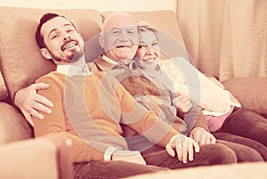 Smiling family hugging sitting on sofa