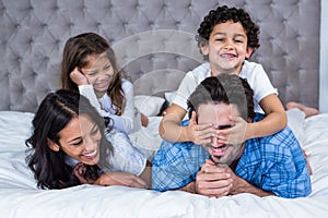 Smiling family laying on the bed