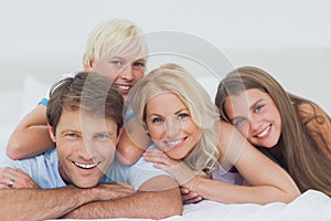 Smiling family lying on bed