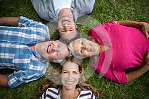 Smiling family lying in the grass