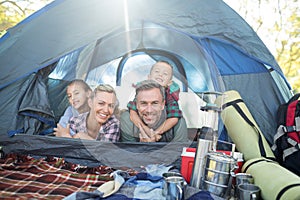 Smiling family lying in the tent