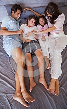 Smiling family lying together on bed