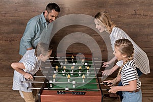 Smiling family playing foosball together