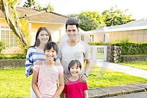 smiling family portrait outside their house