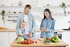 Smiling family preparing meal together in kitchen interior