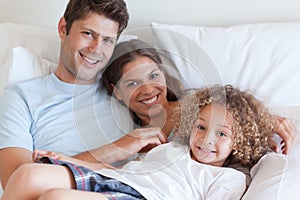 Smiling family relaxing on a bed