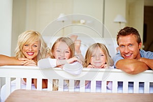 Smiling family relaxing in bed at home. Portrait of smiling family relaxing in bed at home.