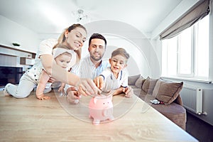 A smiling family saves money with a piggy bank.