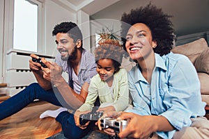 Family sitting on the couch together playing video games, selective focus