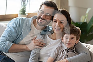 Smiling family with small son relax at home together
