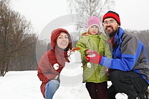 Smiling family and snowman