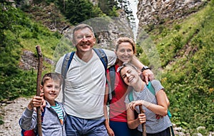 Smiling family standing together on a rugged trail while hiking