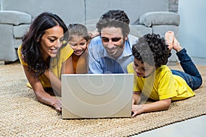 Smiling family using laptop in living room