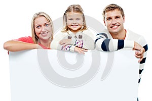 Smiling family with whiteboard in a studio