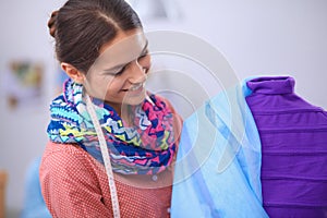 Smiling fashion designer standing near mannequin