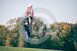 Smiling father carrying daughter on shoulders