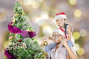 Smiling father and daughter near a Christmas tree